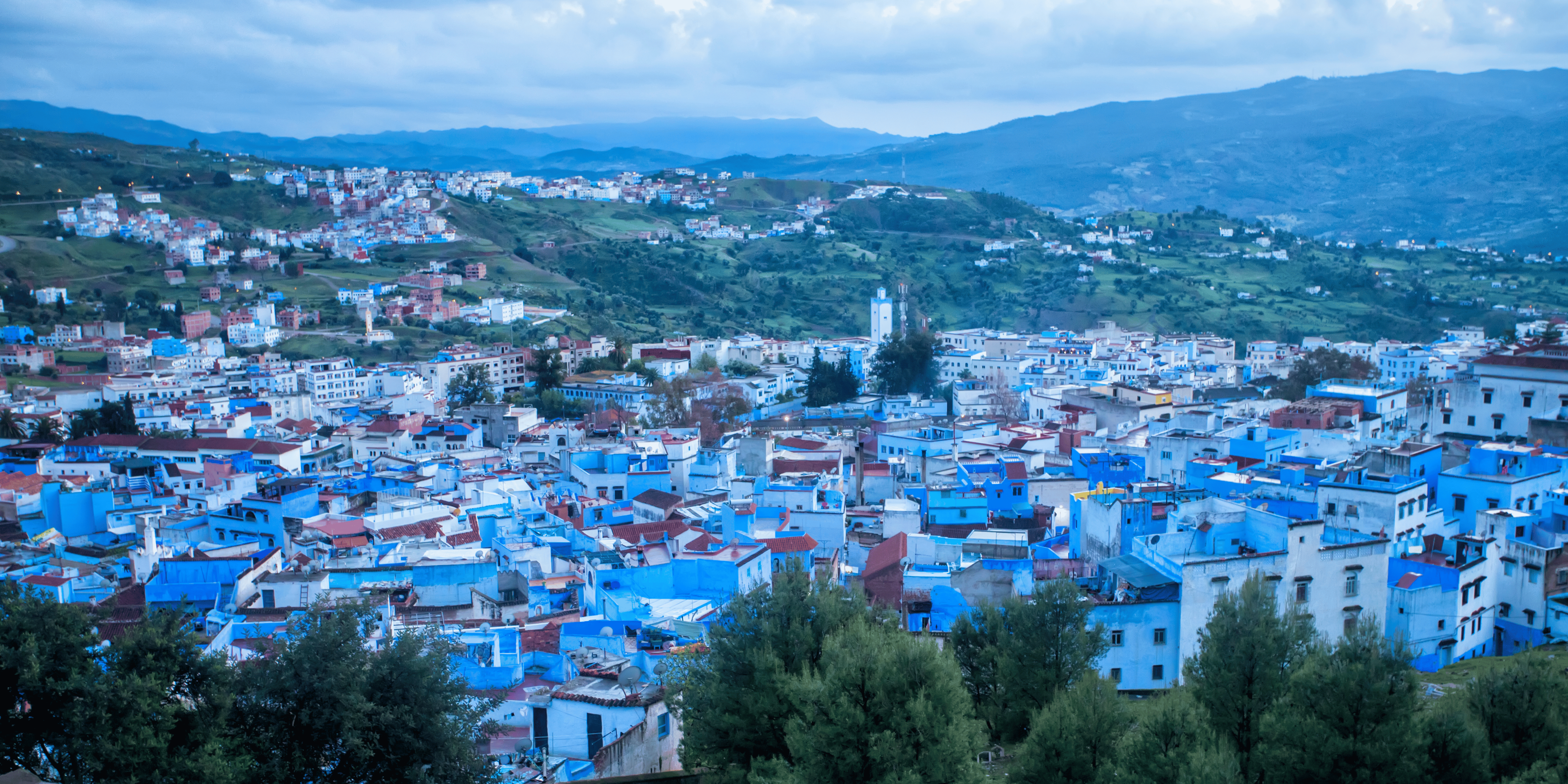 Vibrant streets of Chefchaouen, featuring blue-painted buildings, narrow alleys, and picturesque mountain scenery.