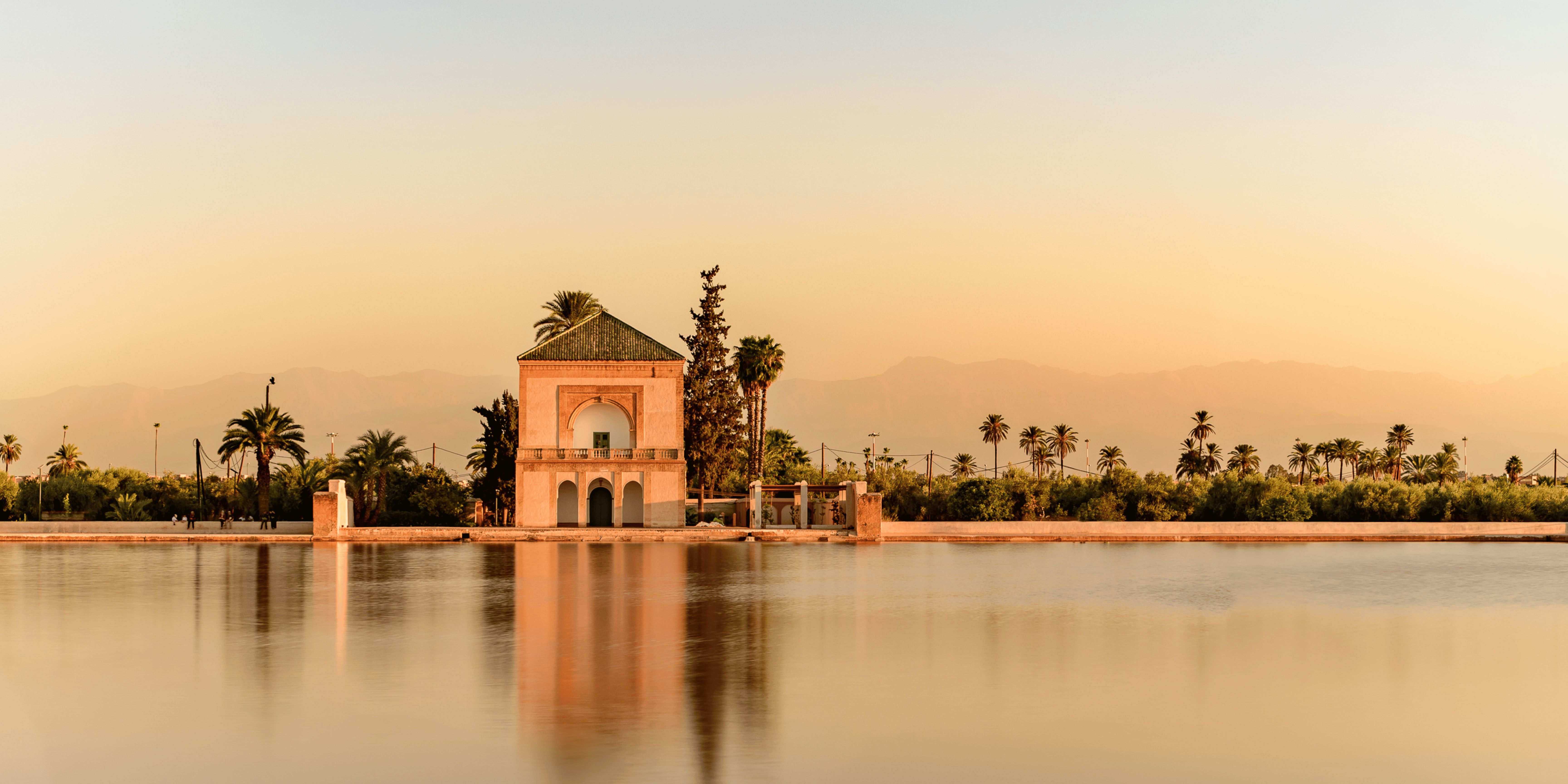 Colorful scene of Marrakech, featuring the bustling Jemaa el-Fnaa square, historic palaces, and vibrant souks.